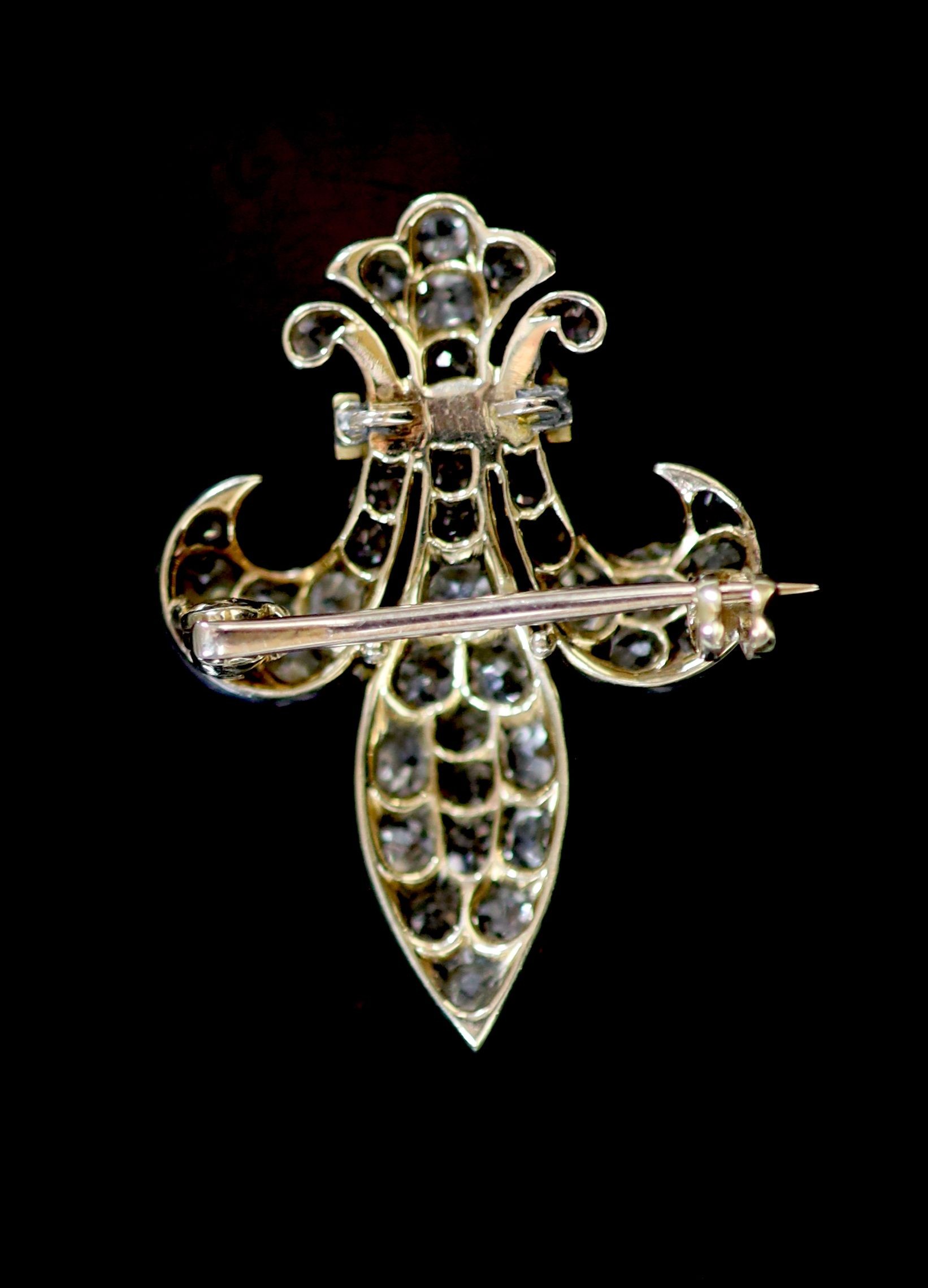 A Victorian gold and platinum, old mine cut diamond and garnet set Fleur de Lys brooch